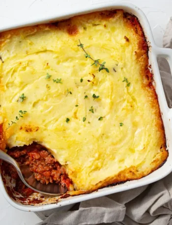 Torta de carne e batata em um refratário de cerâmica com o topo muito dourado e crocante, borbulhando nas pontas.