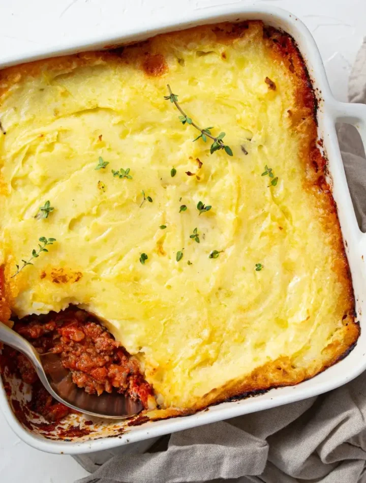 Torta de carne e batata em um refratário de cerâmica com o topo muito dourado e crocante, borbulhando nas pontas.